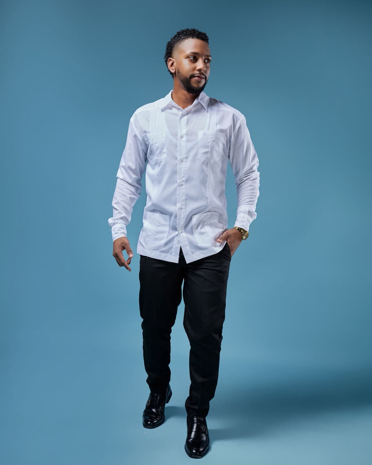 Jose Manuel De Jesus Rodriguez standing in a blue studio portrait